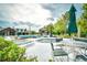 Community pool and spa area featuring comfortable seating, umbrellas, and beautiful landscaping at 5813 Mossy Oaks Dr., North Myrtle Beach, SC 29582