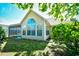 Rear exterior view of the home showcasing a large arched window and sunroom, capturing natural light at 5813 Mossy Oaks Dr., North Myrtle Beach, SC 29582