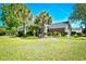 Spacious front yard with manicured lawn, palm trees, lovely bench, and colorful flowerbeds at 5813 Mossy Oaks Dr., North Myrtle Beach, SC 29582