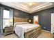 Spacious bedroom with a queen-sized bed, tray ceilings, and an ensuite bathroom at 5813 Mossy Oaks Dr., North Myrtle Beach, SC 29582