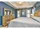 Large bedroom with tray ceilings, a ceiling fan, a bed, and a dresser with mirror at 5813 Mossy Oaks Dr., North Myrtle Beach, SC 29582