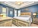 Large bedroom with tray ceilings, a ceiling fan, a bed, and two nightstands at 5813 Mossy Oaks Dr., North Myrtle Beach, SC 29582