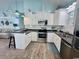 Charming kitchen with white cabinets, stainless steel appliances, and a cozy breakfast bar overlooking the living area at 6001 - Z47 S Kings Hwy., Myrtle Beach, SC 29575