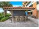 Outdoor bar area with covered seating, a surf board accent, and tiled countertop at 603 S Ocean Blvd. # 912, North Myrtle Beach, SC 29582