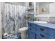 Quaint bathroom with a blue vanity, seashell shower curtain, and coastal accents at 634 Cypress Ln., North Myrtle Beach, SC 29582
