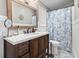 Bathroom featuring wood vanity with black faucet, framed mirror and decorative shower curtain at 634 Cypress Ln., North Myrtle Beach, SC 29582