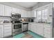 Bright kitchen featuring stainless steel appliances, white cabinets, and a double sink at 634 Cypress Ln., North Myrtle Beach, SC 29582