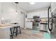 Well-lit kitchen with stainless steel appliances, white cabinets, breakfast bar, and modern fixtures at 634 Cypress Ln., North Myrtle Beach, SC 29582