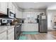 Well-lit kitchen with stainless steel appliances, white cabinets, and a view of the kitchen sink at 634 Cypress Ln., North Myrtle Beach, SC 29582