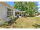 View of backyard and exterior of house featuring a screened porch, greenery, and natural light at 6628 Mallard View Point, Myrtle Beach, SC 29588