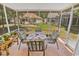 Screened porch with outdoor table and chairs overlooking the backyard and other homes at 6628 Mallard View Point, Myrtle Beach, SC 29588