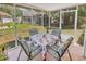 View of the screened in porch with outdoor seating overlooking a grassy yard with other homes at 6628 Mallard View Point, Myrtle Beach, SC 29588