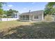 Spacious backyard featuring a screened-in porch, mature trees, and a partial white picket fence at 68 Voyagers Dr., Pawleys Island, SC 29585