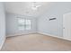 Bedroom features neutral carpet, a ceiling fan, and a large window for natural light at 68 Voyagers Dr., Pawleys Island, SC 29585