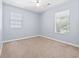 Bedroom with neutral carpet, light blue walls, ceiling fan and two bright windows at 68 Voyagers Dr., Pawleys Island, SC 29585