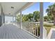 Inviting front porch with white wood flooring and railings offer outdoor relaxation and neighborhood views at 68 Voyagers Dr., Pawleys Island, SC 29585
