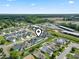 Real estate aerial view featuring a residential neighborhood near a commercial area with ample parking and green space at 712 Hobonny Loop, Longs, SC 29568