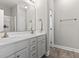 Bathroom featuring a double sink vanity, a large mirror, modern fixtures, and hardwood floors at 712 Hobonny Loop, Longs, SC 29568