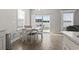 Dining area with white table and chairs, sliding doors to the outside, and a modern chandelier at 712 Hobonny Loop, Longs, SC 29568