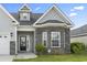 Charming front exterior with stone accents, well manicured lawn, and inviting front porch at 712 Hobonny Loop, Longs, SC 29568