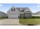 Inviting home with stone accents, well-manicured lawn, and convenient attached garage at 712 Hobonny Loop, Longs, SC 29568