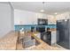 Modern kitchen featuring stainless steel appliances, granite countertops, and sleek white cabinetry at 7200 N Ocean Blvd. # 1058, Myrtle Beach, SC 29572