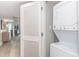Convenient in-unit laundry area with a stacked washer and dryer, located near living area with modern flooring at 7200 N Ocean Blvd. # 1058, Myrtle Beach, SC 29572