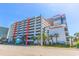 Large parking garage adjacent to the condo complex, landscaped with palm trees and colorful flowers at 7200 N Ocean Blvd. # 1058, Myrtle Beach, SC 29572