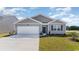 Charming one-story home featuring gray siding, a two-car garage, and well-maintained landscaping at 742 Chazen Way, Longs, SC 29568