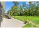 A backyard featuring a concrete patio area, lawn, and a black fence with trees in the background at 747 Gryffindor Dr., Longs, SC 29568