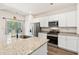 Well-lit kitchen featuring white cabinets, stainless steel appliances, and granite countertops at 747 Gryffindor Dr., Longs, SC 29568