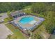 An aerial view of the community pool with lounge chairs, tables, and umbrellas surrounded by landscaping at 847 Flowering Branch Ave., Little River, SC 29566