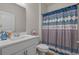 Neat bathroom with white fixtures and patterned shower curtain at 847 Flowering Branch Ave., Little River, SC 29566