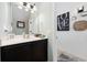 Well-lit half bathroom with vanity, decorative mirror, and stylish wall art at 903 Ocean Pines Ct., North Myrtle Beach, SC 29582
