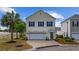 Charming two-story home featuring blue shutters, attached two-car garage, and beautifully landscaped front yard at 903 Ocean Pines Ct., North Myrtle Beach, SC 29582