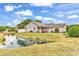 A well-manicured lawn slopes down to a serene pond creating a peaceful backyard at 9616 Sullivan Dr., Murrells Inlet, SC 29576