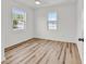 Bright bedroom featuring two double windows, light wood-look floors, and a ceiling fan at 9616 Sullivan Dr., Murrells Inlet, SC 29576