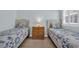 Bright bedroom featuring two twin beds with floral bedding and a small nightstand at 1011 S Ocean Blvd. # 202, North Myrtle Beach, SC 29582