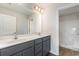 Bathroom with double sink vanity with gray cabinets, white countertops, and a large mirror showing a shower at 1013 Woodside Dr., Conway, SC 29526