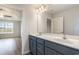 Bathroom with double sink vanity with gray cabinets, white countertops, and a large framed mirror with views of bedroom at 1013 Woodside Dr., Conway, SC 29526