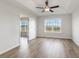 A bright bedroom with hardwood floors, a tray ceiling with fan, and a large window with field views at 1013 Woodside Dr., Conway, SC 29526