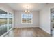 Bright dining room with hardwood floors, a modern chandelier, and a window with outside views and sliding glass doors at 1013 Woodside Dr., Conway, SC 29526