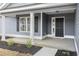 Inviting front porch with classic columns, black shutters, and attractive landscaping at 1013 Woodside Dr., Conway, SC 29526