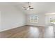 Bright living room featuring large windows, wood flooring, and modern ceiling fan at 1013 Woodside Dr., Conway, SC 29526
