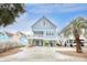 Charming stilted beach house with blue siding, white trim, and a spacious driveway and under house parking at 1023 S Sea Bridge Ct., Surfside Beach, SC 29575