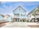 Charming stilted beach house with blue siding, white trim, and a spacious driveway and under house parking at 1023 S Sea Bridge Ct., Surfside Beach, SC 29575