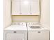 Bright laundry room with white cabinets above a modern, front-loading Maytag washer and dryer at 1023 S Sea Bridge Ct., Surfside Beach, SC 29575