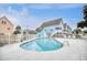Community pool surrounded by a white fence and homes, ideal for relaxation at 1023 S Sea Bridge Ct., Surfside Beach, SC 29575