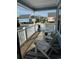 Inviting covered porch with comfortable seating, white railings, and views of the surrounding neighborhood and pool at 1023 S Sea Bridge Ct., Surfside Beach, SC 29575
