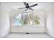 Bright and sunny sitting room featuring a large arched window with neighborhood views and ceiling fan at 1023 S Sea Bridge Ct., Surfside Beach, SC 29575